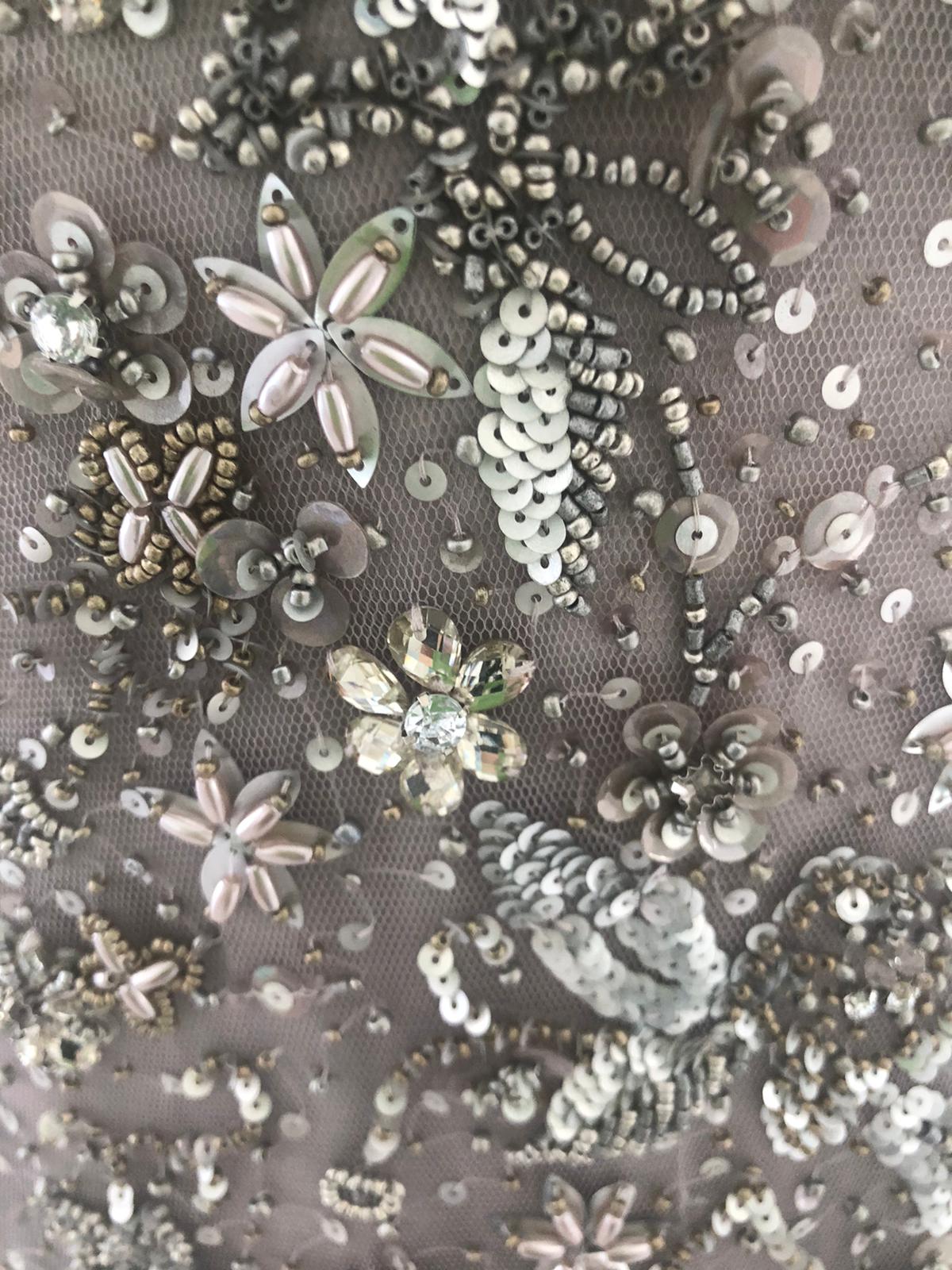 Nahaufnahme der Applikationen des eleganten Abendkleid namens supernova welches bei dressexpress gemietet werden kann. Das Abendkleid ist mit Strassteinen verziert.