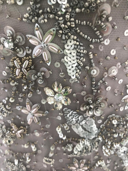 Nahaufnahme der Applikationen des eleganten Abendkleid namens supernova welches bei dressexpress gemietet werden kann. Das Abendkleid ist mit Strassteinen verziert.